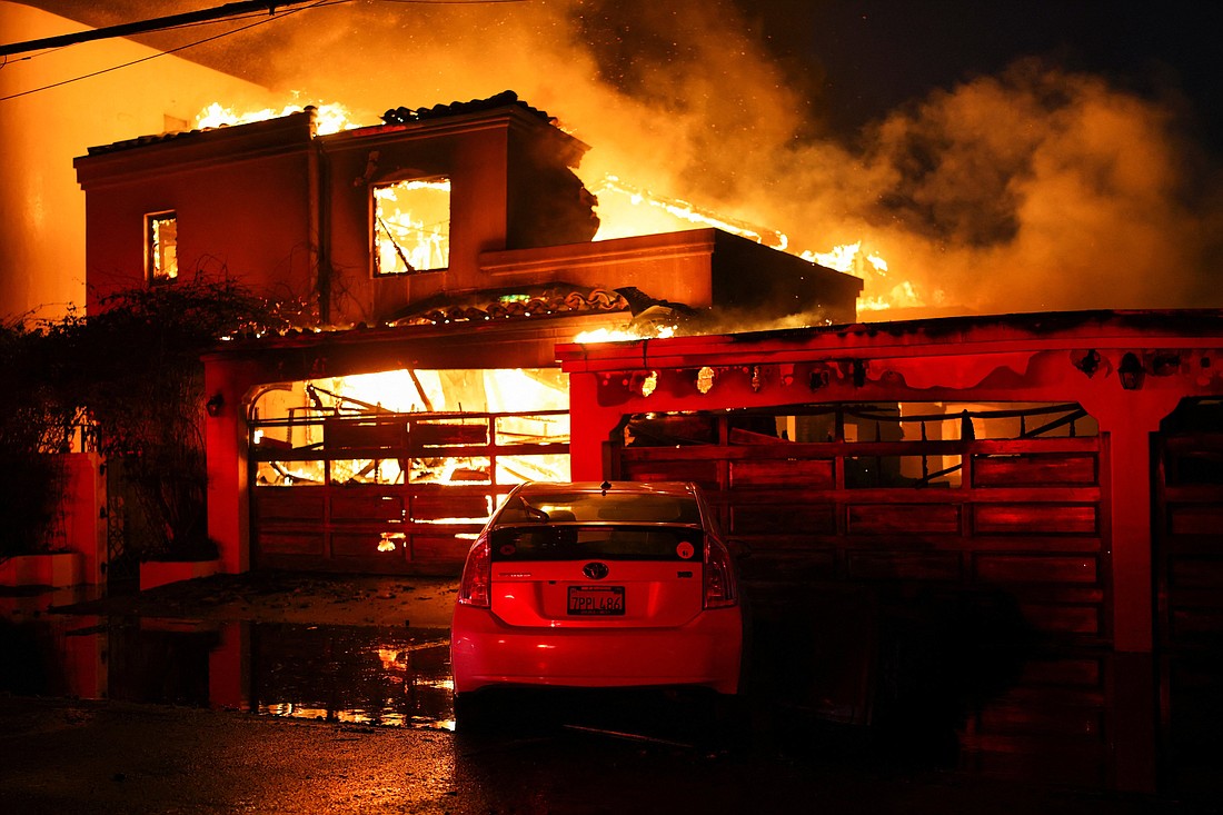 Smoke and flames rise from a burning home in Malibu, Calif. Jan. 8, 2025, as powerful winds fueling devastating wildfires in the Los Angeles area force people to evacuate. Several Catholic parishes opened their doors to families evacuated from their homes as wind-driven fires continued to burn through parts of Los Angeles County Jan. 8. (OSV News photo/Daniel Cole, Reuters)