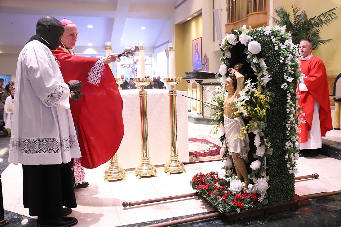 Bishop O'Connell blesses a statue of St. Sebastian at the start of Mass Jan. 25. John Batkowski photo