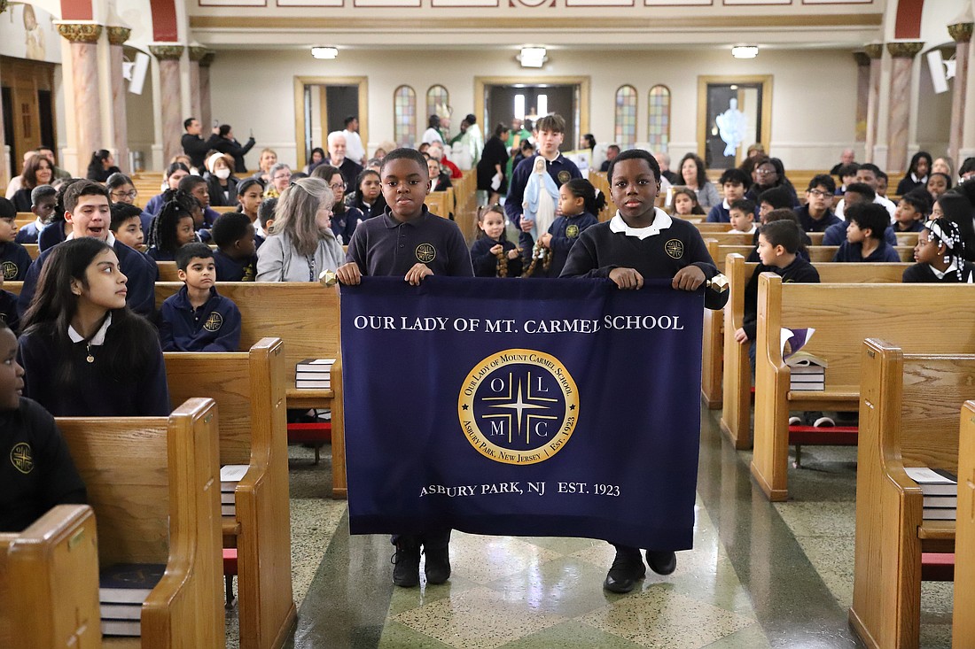 Two Our Lady of Mount Carmel School, Asbury Park, students carry their school banner during the Entrance Procession of the Catholic Schools Week Mass that Bishop O'Connell celebrated Jan. 30. John Batkowski photo