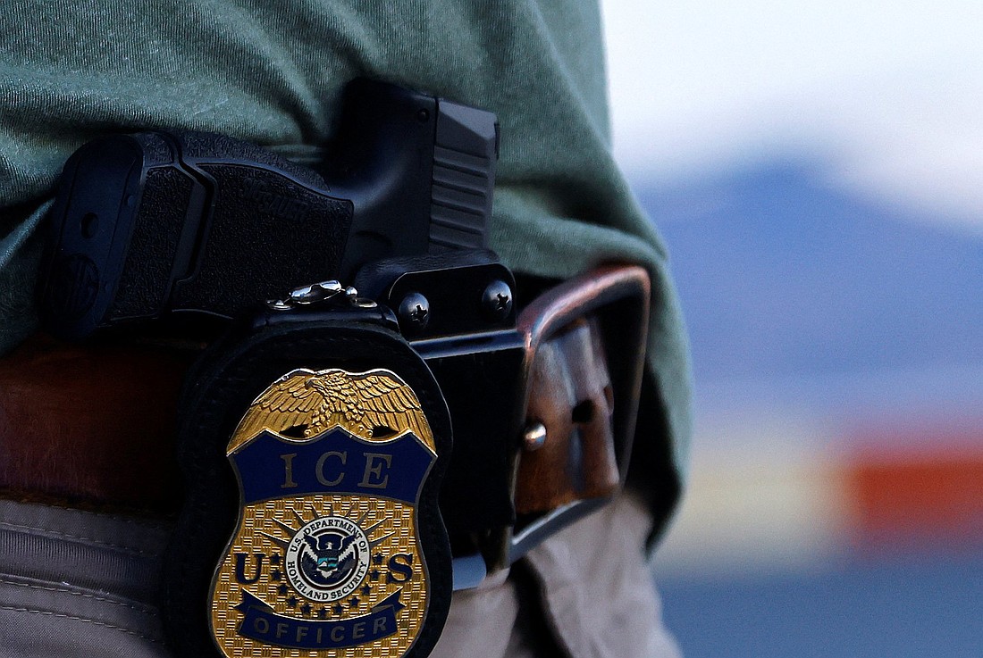 The badge and gun of a U.S. Immigration and Customs Enforcement agent is seen during an operation with migrants being transferred to a plane to be expelled under U.S. Title 42 from the United States to their home country by ICE and Border Patrol agents, at the airport in El Paso, Texas, May 10, 2023. (OSV News photo/Jose Luis Gonzalez, Reuters)