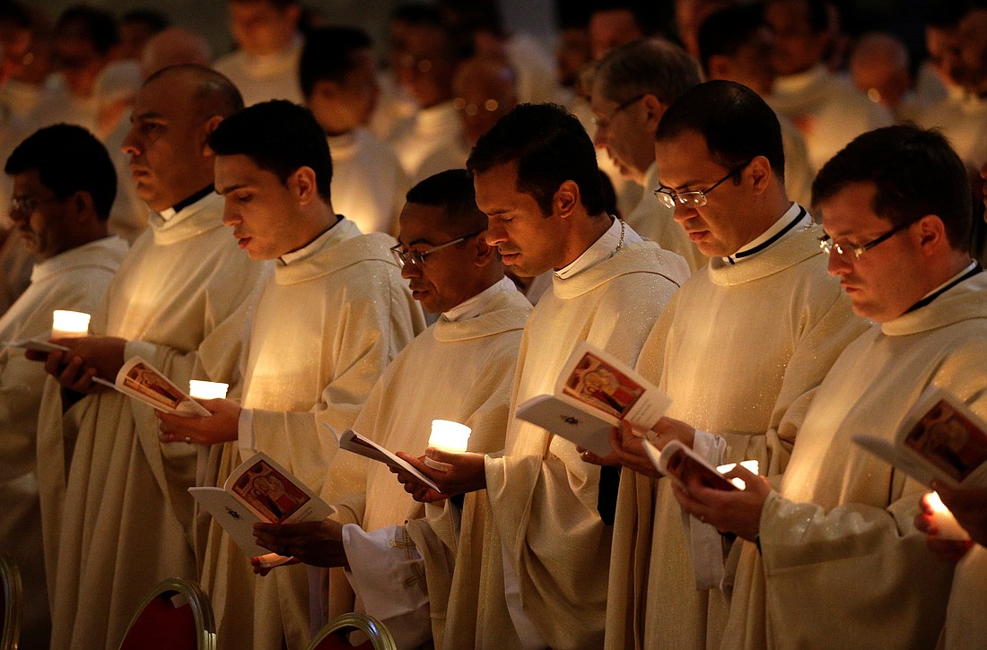 Priests hold candles as they wait for Pope Francis to arrive for Mass with consecrated women and men marking the feast of the Presentation of the Lord and the World Day for Consecrated Life in St. Peter's Basilica at the Vatican Feb. 2, 2018. (CNS photo/Max Rossi, Reuters)