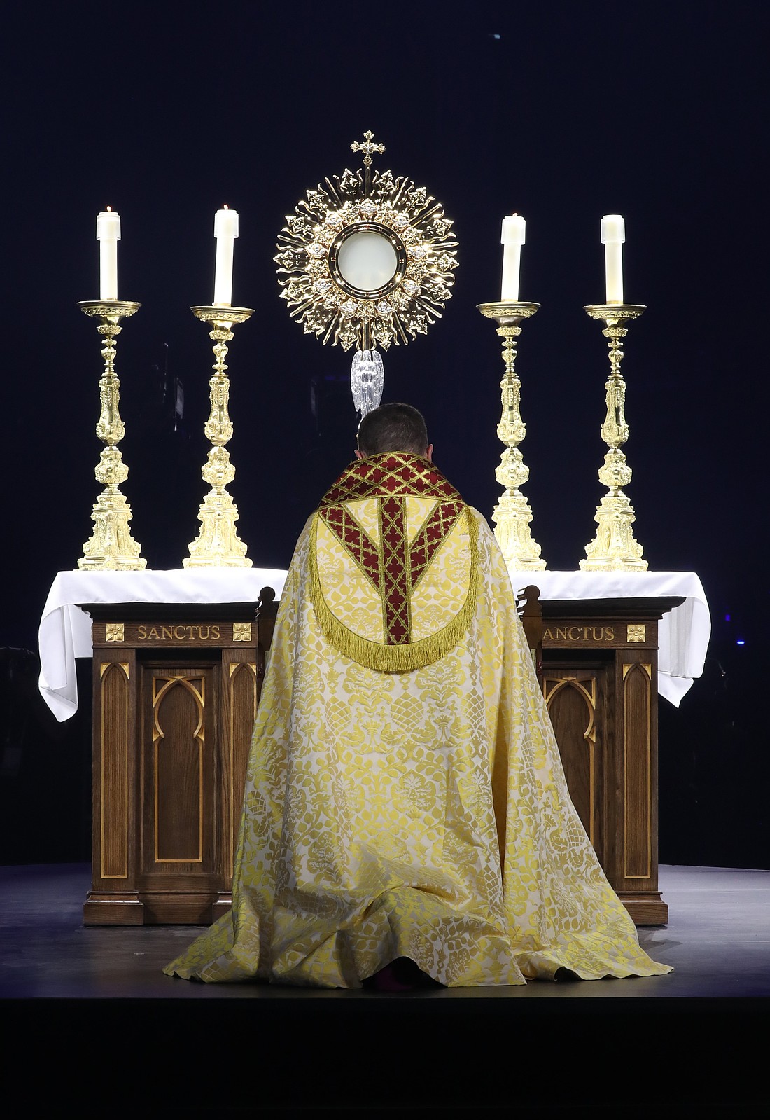 Bishop Andrew H. Cozzens of Crookston, Minn., chairman of the board of the National Eucharistic Congress, Inc., kneels in prayer before the monstrance during Eucharistic adoration at the opening revival night July 17, 2024, of the 10th National Eucharistic Congress at Lucas Oil Stadium in Indianapolis. (OSV News photo/Bob Roller)