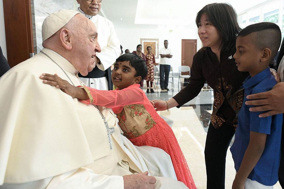 Pope Francis receives a hug from a child as he meets migrants, refugees, orphans, the elderly and the sick at the apostolic nunciature in Jakarta, Indonesia, Sept. 3, 2024. The people the pope met are assisted by the Community of Sant'Egidio, the Dominican sisters and Jesuit Refugee Service. (CNS photo/Vatican Media)