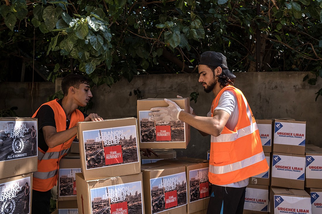 Workers with Caritas Lebanon, in partnership with Catholic Relief Services, are pictured in an undated photo distributing food and hygiene kits to people who affected following an Aug. 4, 2020, blast in Beirut's port area. (OSV News photo/Stefanie Glinski for Catholic Relief Services).