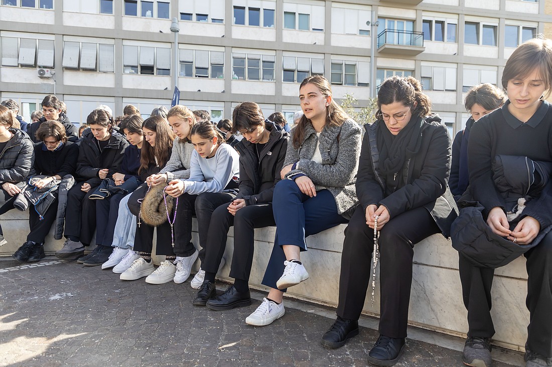 People pray in the courtyard outside Rome's Gemelli hospital Feb. 23, 2025, where Pope Francis is being treated for double pneumonia. (CNS photo/Pablo Esparza)