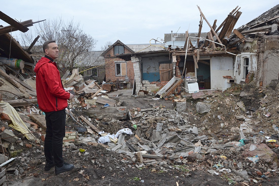 Father Wojciech Stasiewicz, the director of Religious Mission of Caritas-Spes in the eastern Diocese of Kharkiv-Zaporizhzhia, Ukraine, is seen in Balakliya, near Kharkiv, in front of a destroyed house in 2022. (OSV News photo/courtesy Father Wojciech Stasiewicz)