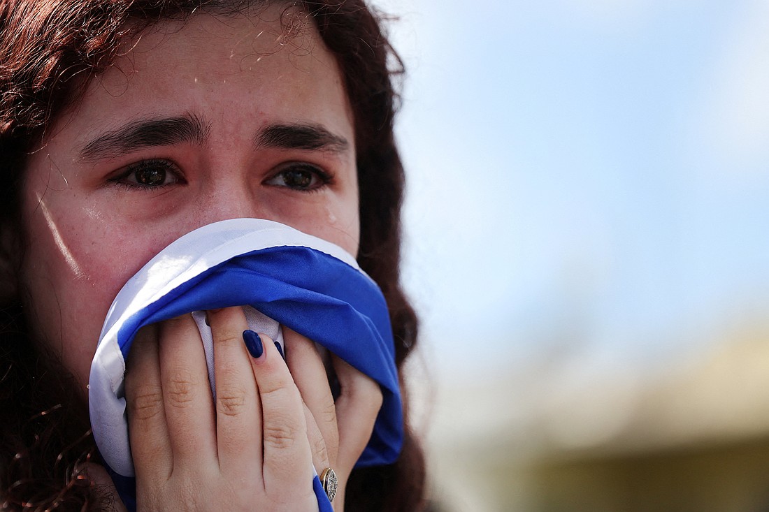 A young woman cries as people gather in Tel Aviv, Israel, Feb. 20, 2025, on the day the bodies of deceased Israeli hostages, identified at the time by Palestinian militant groups as Oded Lifschitz, Shiri Bibas and her two children Kfir and Ariel Bibas, who were kidnapped during the deadly Oct. 7, 2023, attack by Hamas, are handed over under the terms of a ceasefire between Hamas and Israel. (OSV News photo/Ammar Awad, Reuters)