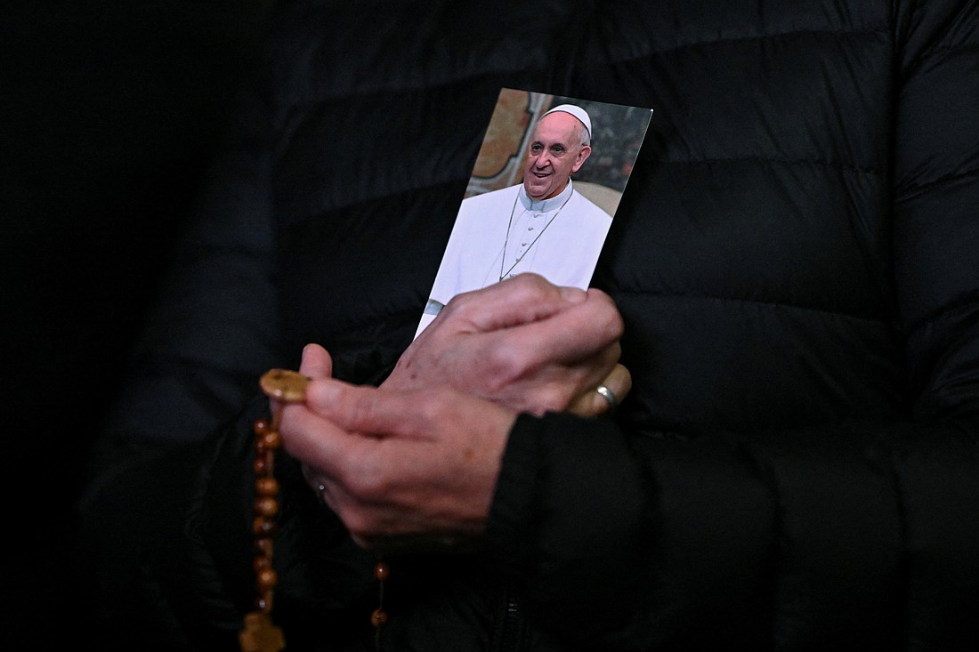 A person holds a picture of Pope Francis and a rosary during a prayer service in St. Peter's Square at the Vatican Feb. 25, 2025, as Pope Francis continued his hospitalization. (OSV News photo/Dylan Martinez, Reuters)