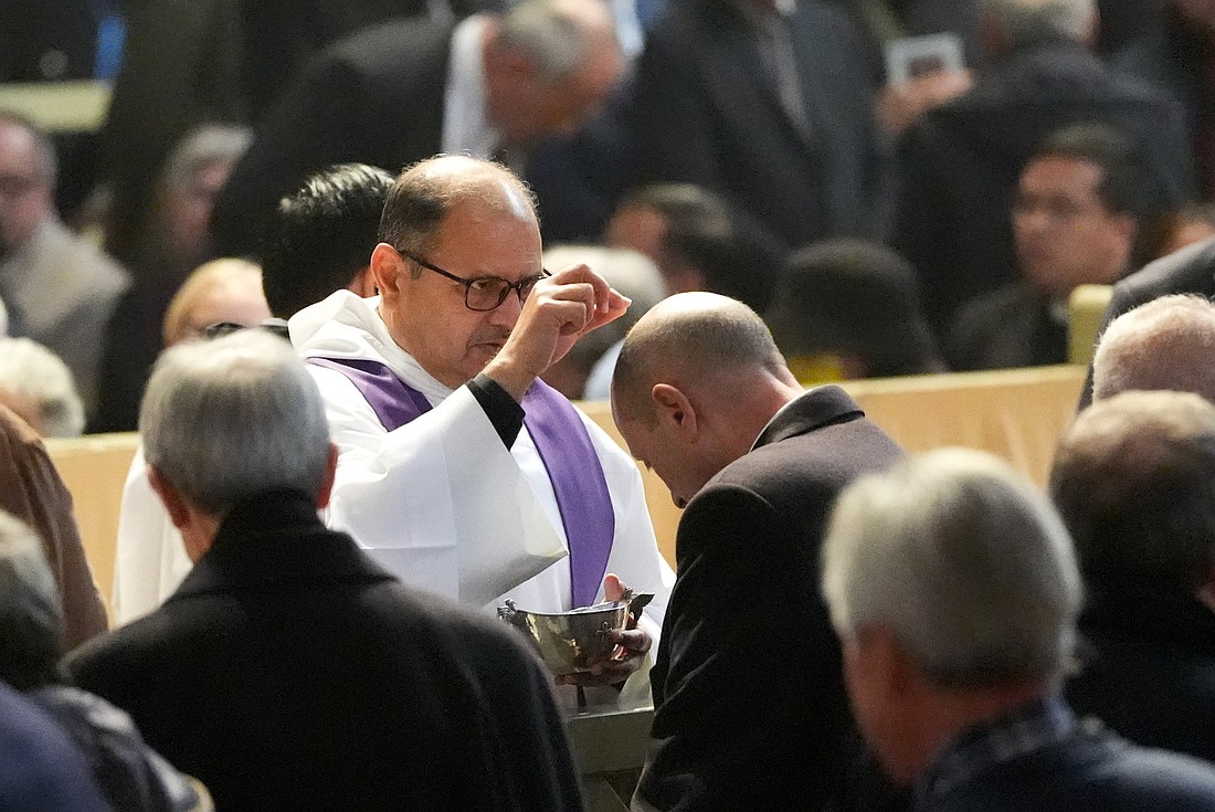 A priest distributes ashes during Ash Wednesday Mass at the Basilica of Santa Sabina in Rome March 5, 2025. (CNS photo/Lola Gomez)