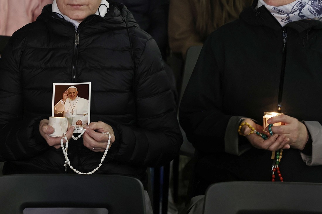 Religious sisters hold rosaries, candles and an image of Pope Francis as they listen to an audio message from him before praying the rosary for his health in St. Peter's Square at the Vatican March 6, 2025. (CNS photo/Pablo Esparza)