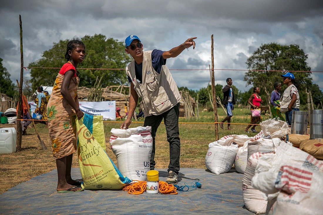 A Catholic Relief Services worker is pictured in a file photo helping a young woman at a food distribution area in Marojela village, located in the Marolinta commune in southern Madagascar's Beloha District. On this day, 416 people from six villages received food. Over the past several years, the southern region of Madagascar has been affected by recurring droughts. (OSV News photo/Jim Stipe, courtesy Catholic Relief Services)