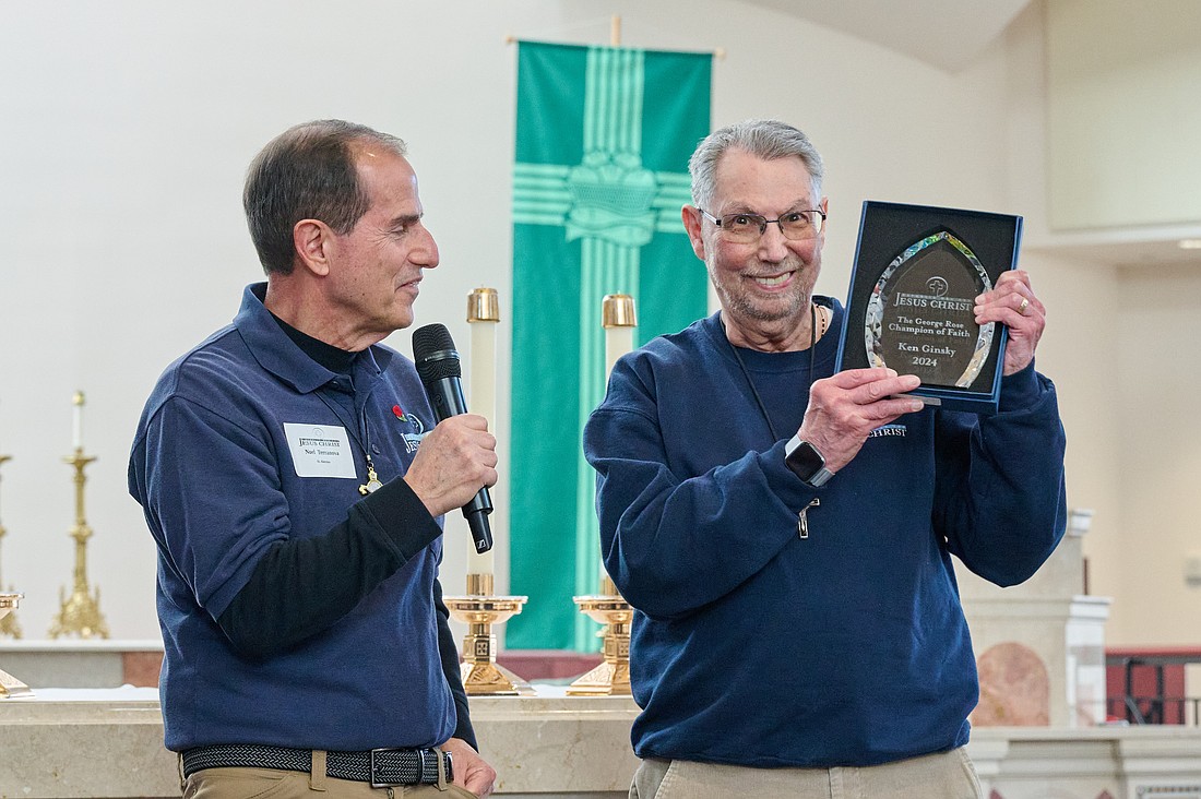 Ken Ginsky holds up the George Rose Champion of Faith Award he was presented during the Catholic Men's Conference. At left, is Noel Terranova, director of operations for the Catholic Men for Jesus Christ. Mike Ehrmann photo