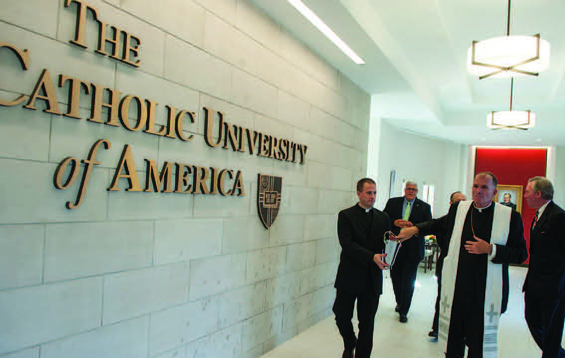 Bishop O’Connell blesses the foyer of the newly dedicated Father O’Connell Hall on Oct. 17, 2014. Assisting the Bishop at left is then-Rev. Mr. Jason Parzynski. Father Parzynski is currently pastor of St. David the King Parish, Princeton Junction.