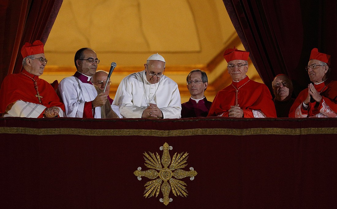 El Papa Francisco inclina la cabeza en oración durante su aparición en la noche electoral en el balcón central de la basílica de San Pedro en el Vaticano el 13 de marzo de 2013. La multitud se unió al Papa en una oración silenciosa después de que él les pidiera que rezaran para que Dios le bendijera. (Foto CNS/Paul Haring)