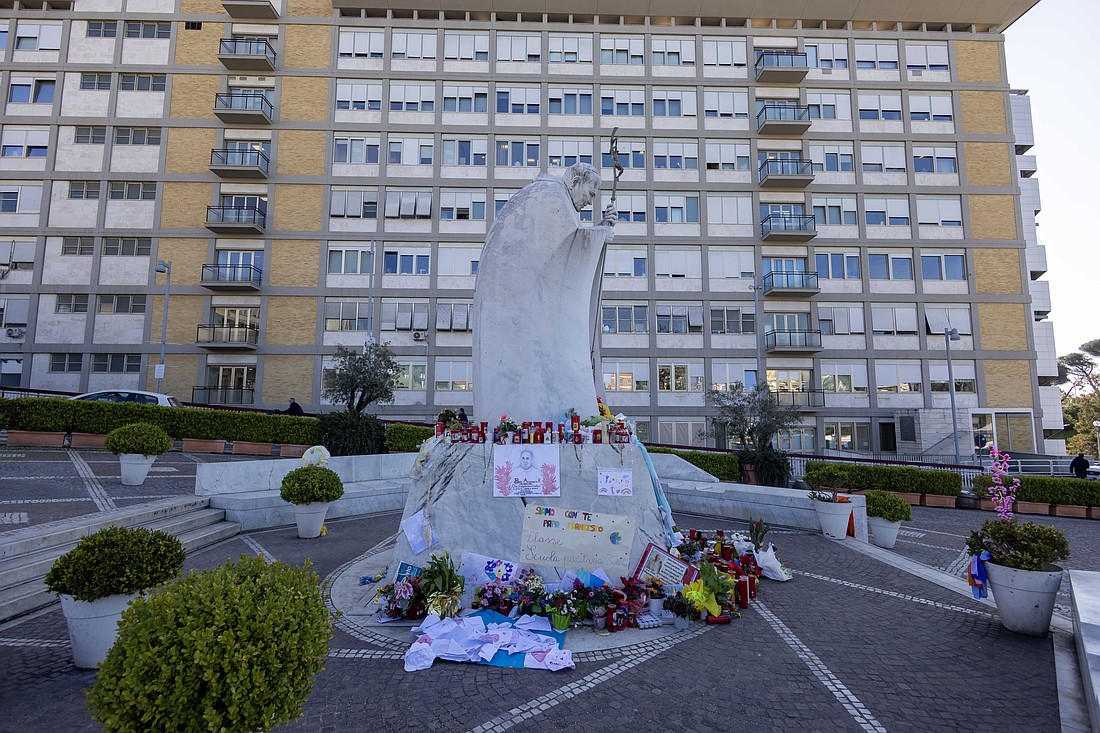 Devotional items, drawings and messages are seen at the base of a statue of St. John Paul II outside of Rome's Gemelli hospital March 19, 2025. (CNS photo/Pablo Esparza)