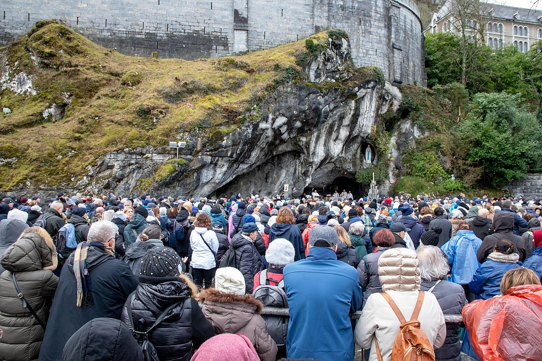 People pray Feb. 10, 2024, at the grotto at the Sanctuary of Our Lady of Lourdes, where St. Bernadette Soubirous witnessed 18 Marian apparitions beginning on Feb. 11, 1858, in Lourdes, France. In a joyful moment after the rosary on April 16, 2025 -- St. Bernadette Soubirous' feast day -- the shrine's rector, Father Michel Daubanes, announced that a 72nd miracle from the famed pilgrimage site had been recognized. (OSV News photo/courtesy Lourdes Sanctuary).
