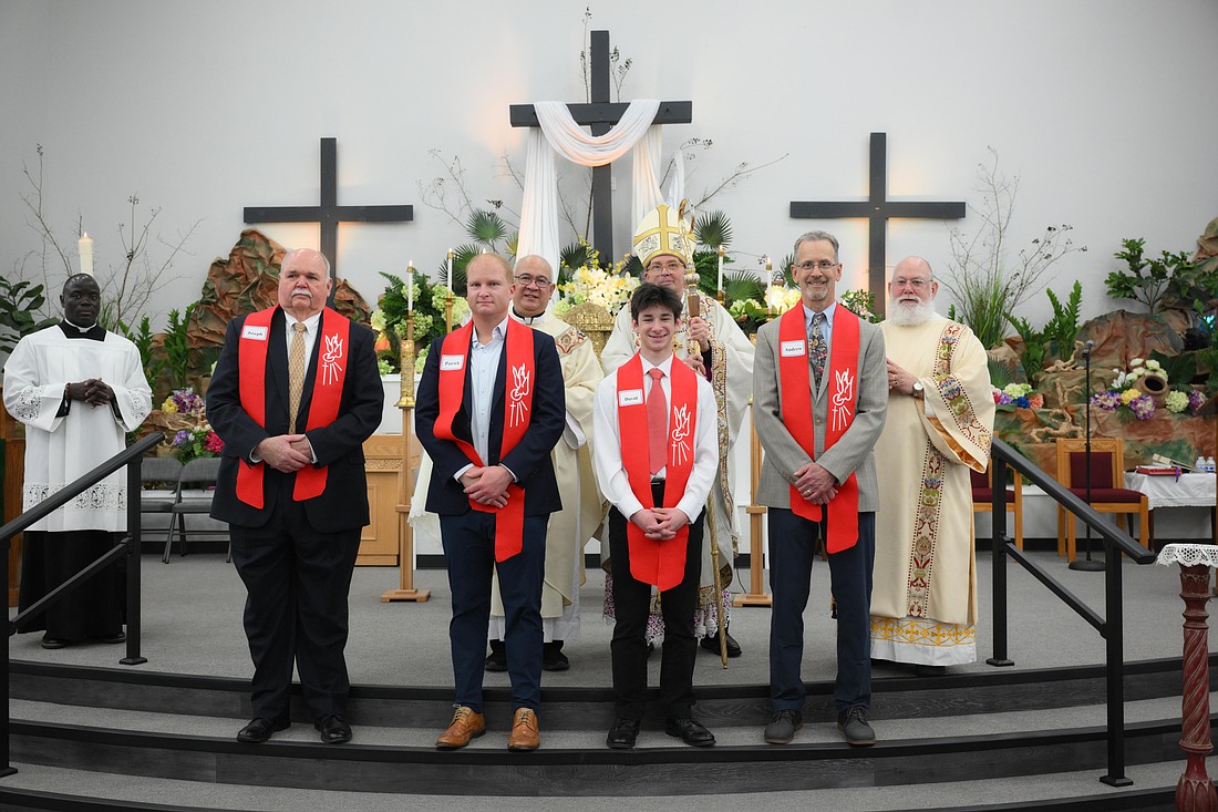 Bishop O'Connell, along with Our Lady Queen of Peace Parish pastor, Father Joe Noche and Deacon Lee Zito pose for a photo with the four men who received Sacraments during the Easter Vigil. Mike Ehrmann photo