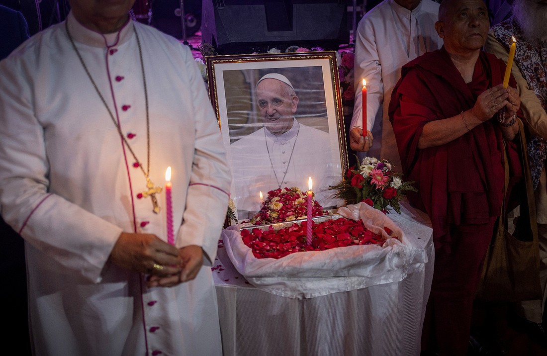 People hold candles in front of a picture of Pope Francis in New Delhi, India, April 21, 2025, after his death was announced by the Vatican. Pope Francis, formerly Argentine Cardinal Jorge Mario Bergoglio, died April 21 at age 88.  (OSV News photo/Adnan Abidi, Reuters)