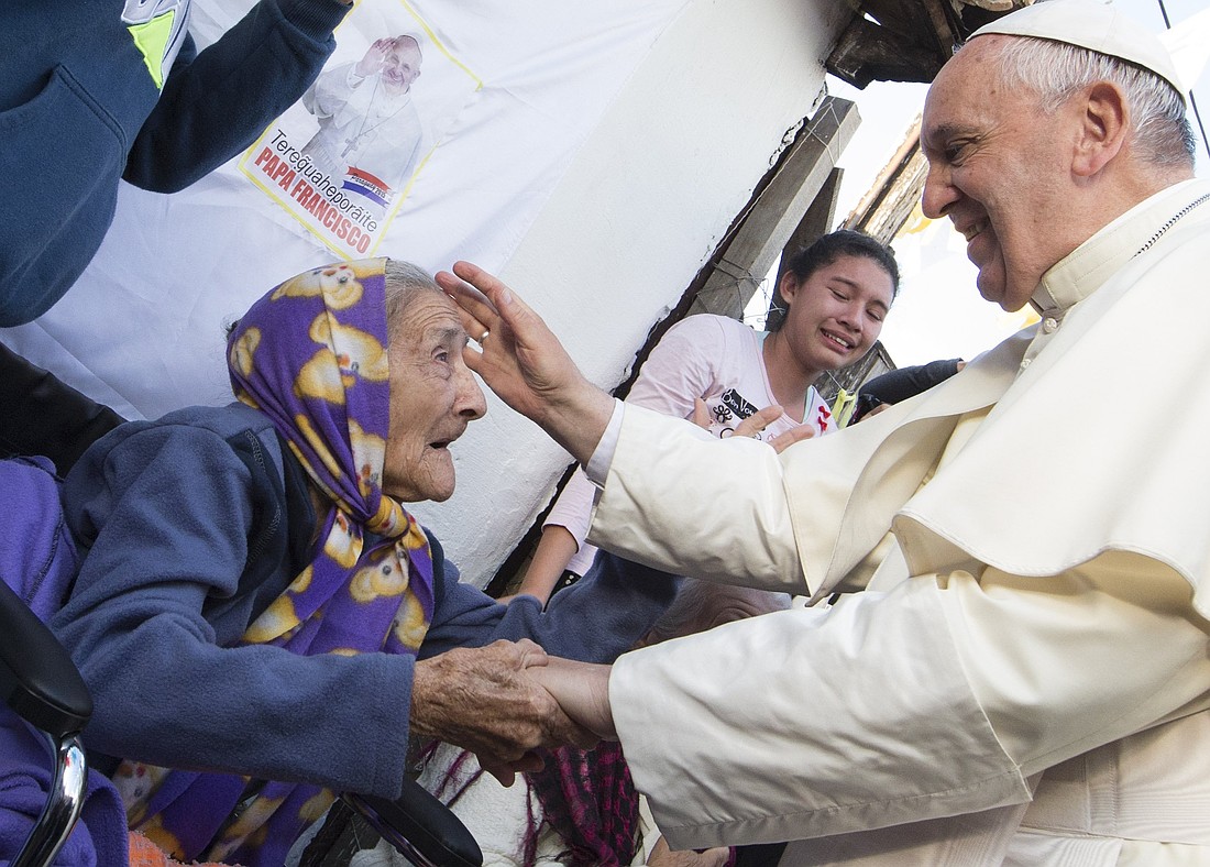 El Papa Francisco saluda a una anciana mientras se reúne con la gente en un barrio pobre de Asunción, Paraguay, en esta foto de archivo del 12 de julio de 2015. El cuidado pastoral de los pobres y los necesitados ha sido el énfasis del pontificado del Papa Francisco. (Foto CNS/Paul Haring)