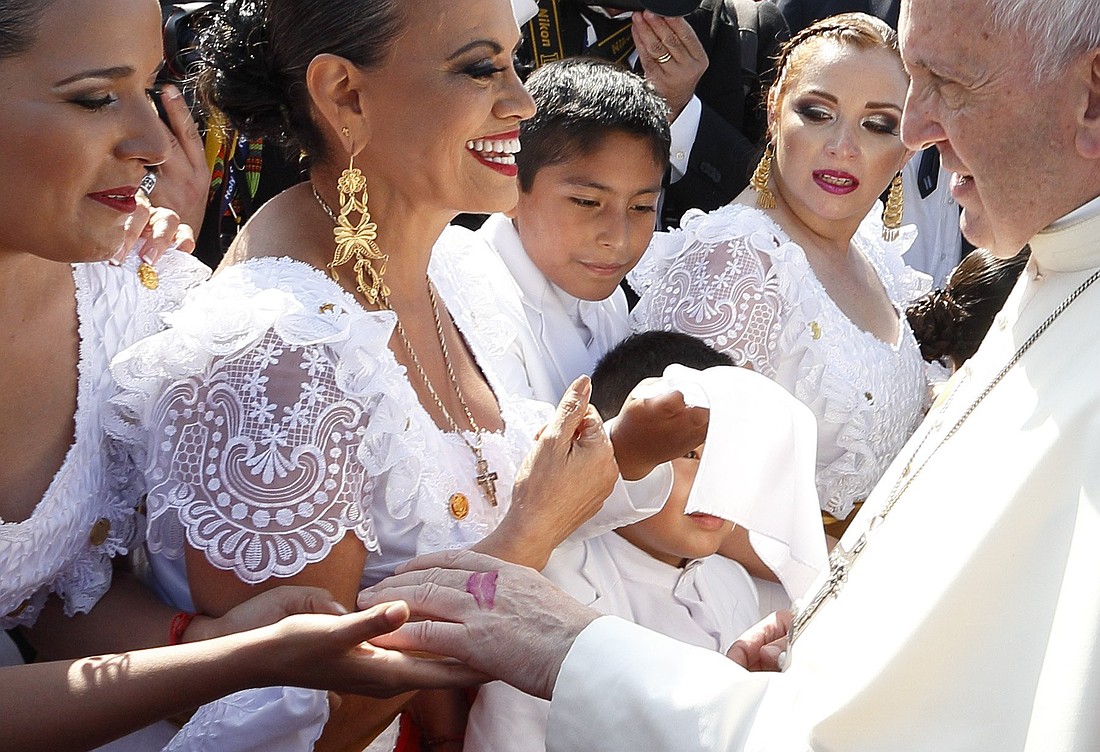 Pope Francis greets dancers upon his arrival at the international airport in Trujillo, Peru, Jan. 20. Lipstick from a kiss is seen on the pope's hand. The pontiff, formerly Argentine Cardinal Jorge Mario Bergoglio, died April 21, 2025, at age 88. (CNS photo/Paul Haring)
