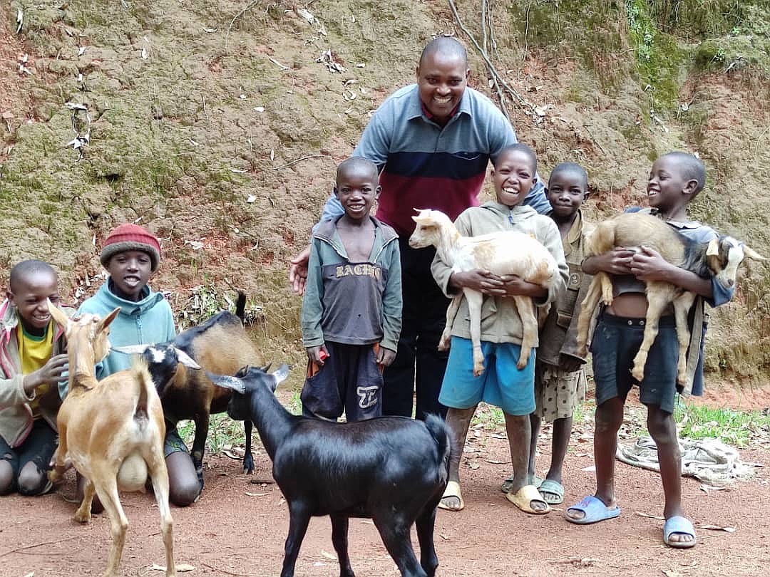 Father Mathias Kayemba, pastor of Our Lady Queen of Apostles in Rwanda, stands with children who are beneficiaries of the goats purchased with funds collected by parishioners of St. Anselm, Wayside. Courtesy photos