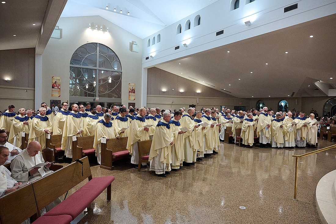 Los sacerdotes de la Diócesis se ponen de pie y renuevan su compromiso sacerdotal al servicio de la comunidad diocesana. Fotos de Mike Ehrmann.
