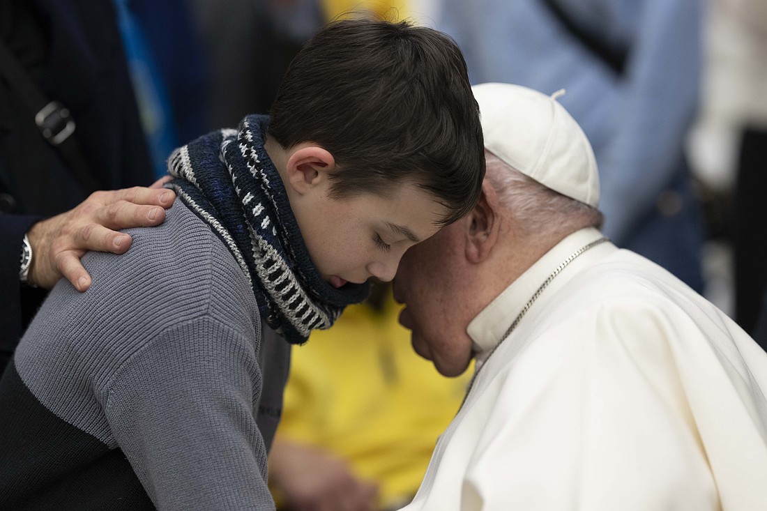 Pope Francis shares a moment with a child during his weekly general audience in the Paul VI Audience Hall at the Vatican Jan. 22, 2025. (CNS photo/Vatican Media)