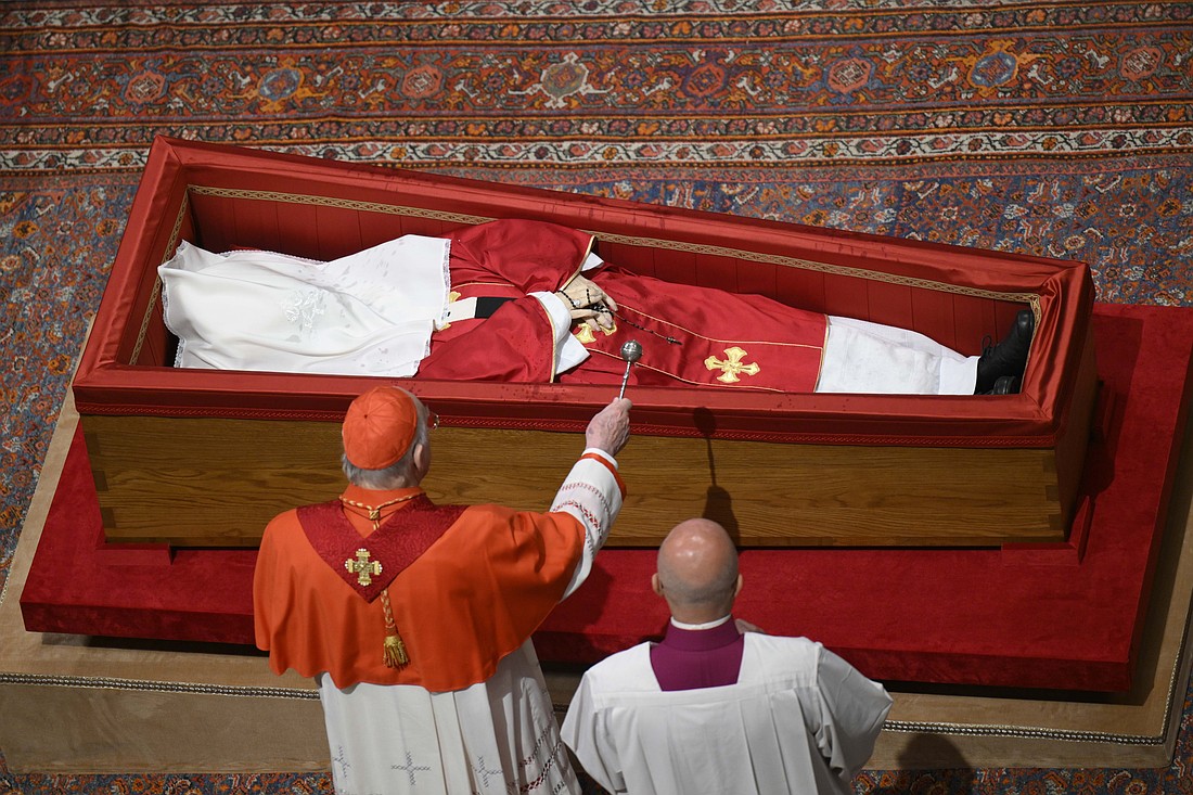 U.S. Cardinal Kevin J. Farrell, chamberlain of the Holy Roman Church, sprinkles Pope Francis' body with holy water before his casket is sealed during a prayer service in St. Peter's Basilica at the Vatican April 25, 2025. (CNS photo/Vatican Media)
