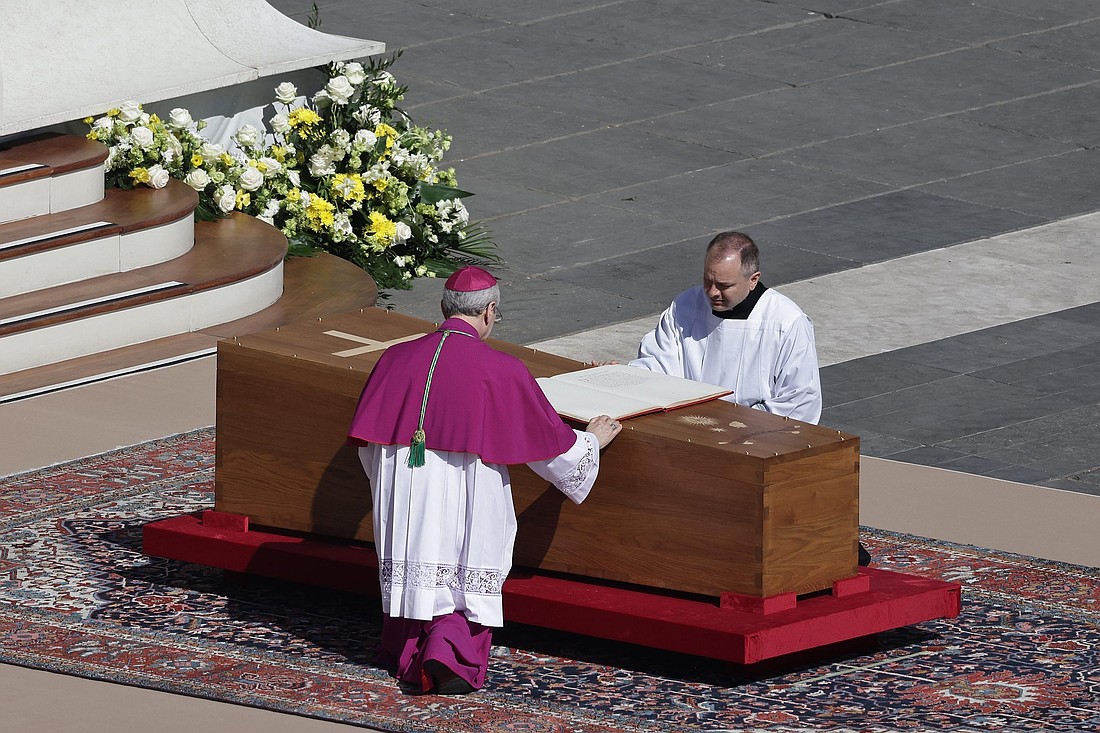 El arzobispo Diego Ravelli, a la izquierda, coloca un Libro de los Evangelios abierto sobre el ataúd del Papa Francisco al comienzo de la Misa exequial del Papa el 26 de abril de 2025, en la Plaza de San Pedro en el Vaticano. (Foto CNS/Vatican Media)