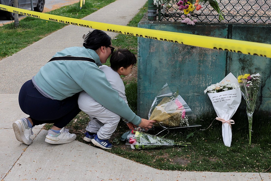 A woman and a child place flowers at a makeshift memorial in Vancouver, British Columbia, April 27, 2025, after a vehicle rammed into a crowd at the Lapu Lapu Day block party. A man drove an Audi SUV into people at the Filipino heritage festival hours earlier April 26, killing at least 11 people and injuring multiple others, police said. (OSV News photo/Chris Helgren, Reuters)