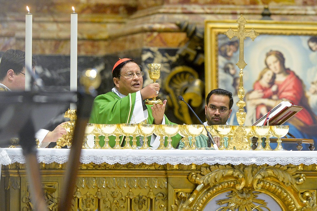 Cardinal Charles Bo, archbishop of Yangon, Myanmar, and president of the Federation of Asian Bishops' Conferences, elevates the chalice during Mass in St. Peter's Basilica as part of the assembly of the Synod of Bishops at the Vatican Oct. 23, 2023. (CNS photo/Stefano Carofei, pool)