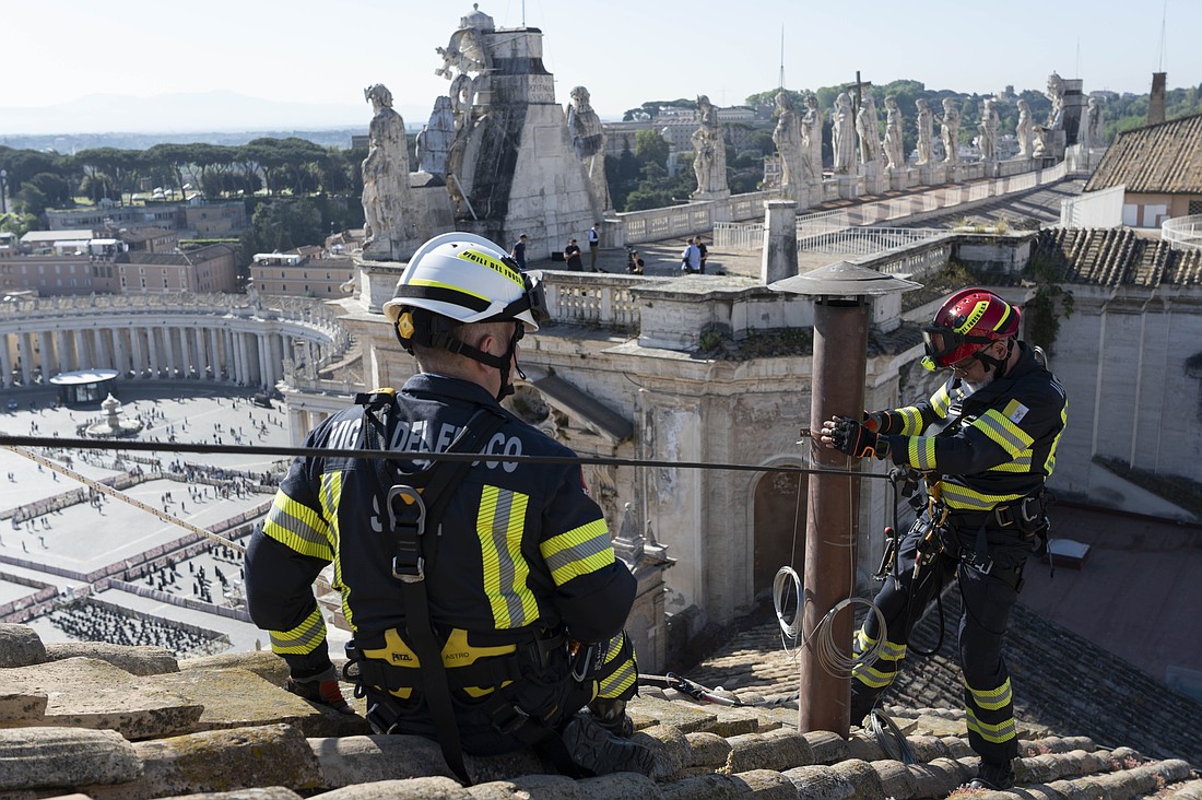 Vatican firefighters install the chimney on the roof of the Sistine Chapel at the Vatican May 2, 2025. Connected to a stove in the chapel where the ballots will be burned during the conclave to elect a new pope, the chimney will signal to the world whether a new pope has been elected. (CNS photo/Vatican Media)