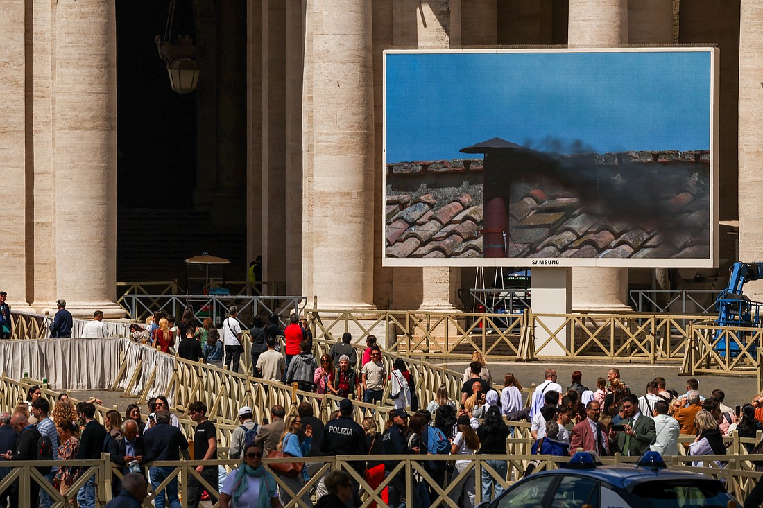 The crowd looks on in St. Peter's Square at the Vatican as a large screen shows black smoke billowing from the chimney on the Sistine Chapel May 8, 2025, the second day of the conclave. The black smoke indicated that cardinals did not elect a new pope. (OSV News photo/Alkis Konstantinidis, Reuters)