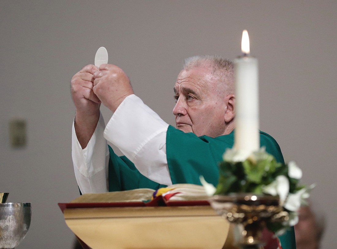 Father Venza consecrates the Eucharist during a Mass he celebrated in this 2018 Monitor file photo