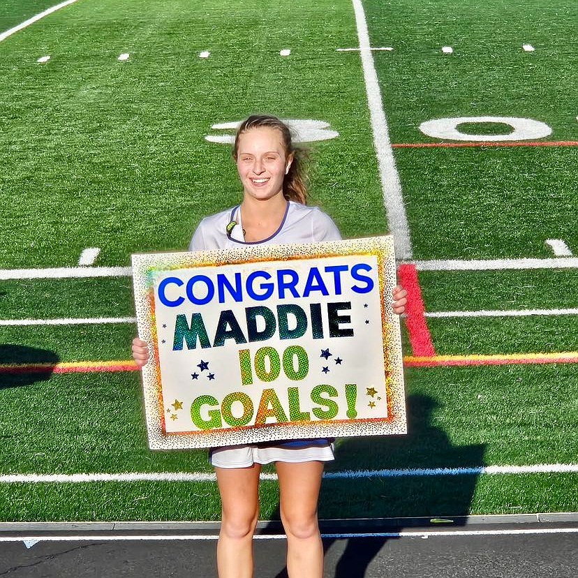 Donovan Catholic junior Maddie Koehler holds up a congratulatory sign for making her 100th lacrosse goal April 14. Courtesy photo