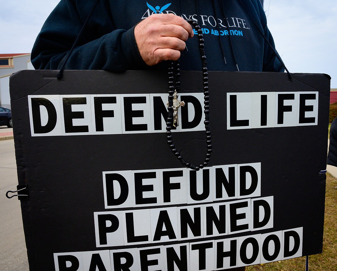A pro-life advocate holds a rosary and sign in this file photo from Nov. 3, 2019. Planned Parenthood released its new annual report for 2023-2024, their first covering a period of time after the Dobbs decision. (OSV News photo/Sam Lucero, The Compass)