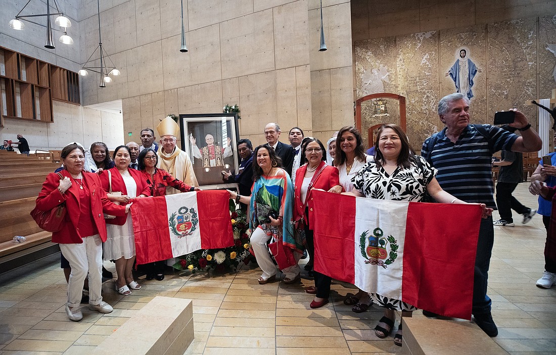A group of Peruvian faithful pose with Archbishop José H. Gomez around a portrait of Pope Leo XIV following a special Mass celebrating the new pontiff on May 9. (OSV News photo/Victor Alemán, Angelus).