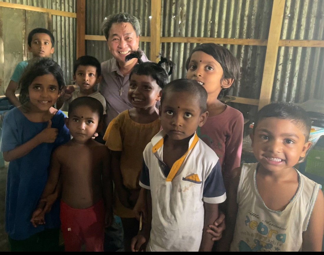 Father Alindogan, back row, is shown with young people during a 2024 mission visit to Bangladesh. Courtesy photo