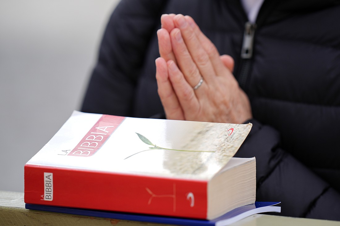 A religious woman with a rosary and a Bible prays during Pope Francis' recitation of the Angelus in St. Peter’s Square at the Vatican Jan. 26, 2025. (CNS photo/Lola Gomez)