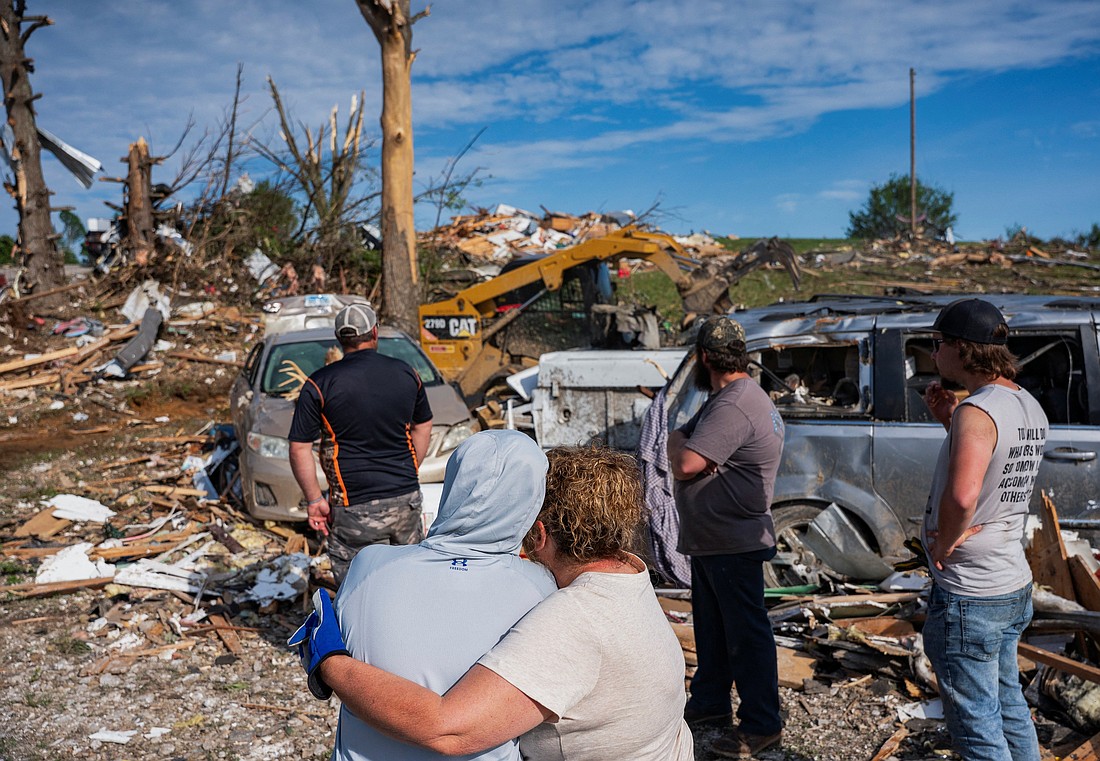 People embrace as they watch volunteers clean up the debris in the Sunshine Hills neighborhood in London, Ky., May 18, 2025, after a series of tornadoes hit the area May 16. At least 27 people have been killed by storm systems that swept across part of the U.S. Midwest and South, with Kentucky Gov. Andy Beshear announcing May 17 that 18 of the deaths came in his state and 10 others were hospitalized in critical condition. (OSV News photo/Seth Herald, Reuters)