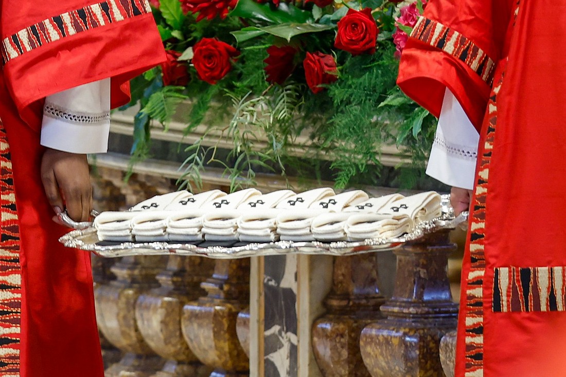 Deacons hold palliums -- woolen bands worn by metropolitan archbishops to symbolize their authority and unity with the pope -- during Mass for the feast of Sts. Peter and Paul in St. Peter's Basilica at the Vatican June 29, 2024. (CNS photo/Lola Gomez)