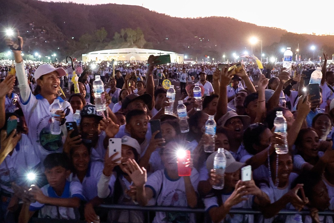 Floodlights and mobile phones shine as people greet Pope Francis in the popemobile as he circles the crowd following an outdoor Mass in Tasitolu, Timor-Leste, Sept. 10, 2024. (CNS photo/Lola Gomez)