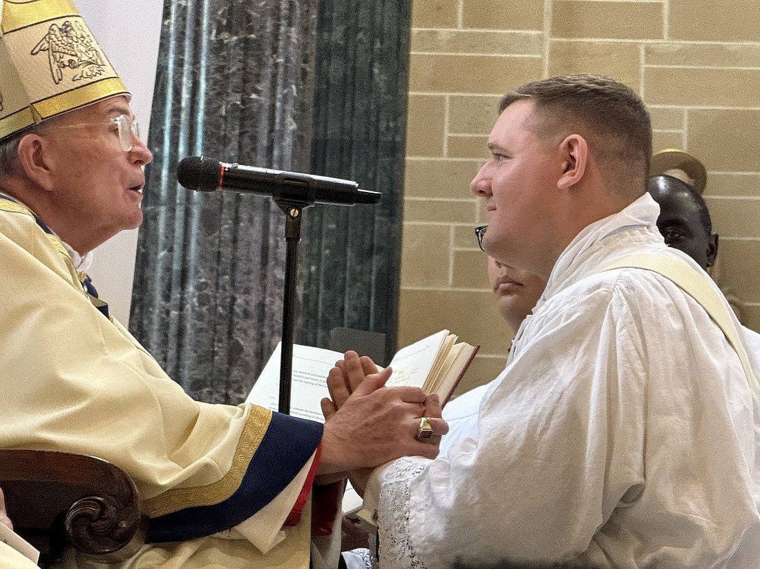 Bishop David M. O'Connell, C.M., holds the hands of Rev. Mr. Alan Bridges during the Promise of Obedience during the Mass for his priestly ordination May 31 at St. Mary of the Assumption Cathedral, Trenton. EmmaLee Italia photo