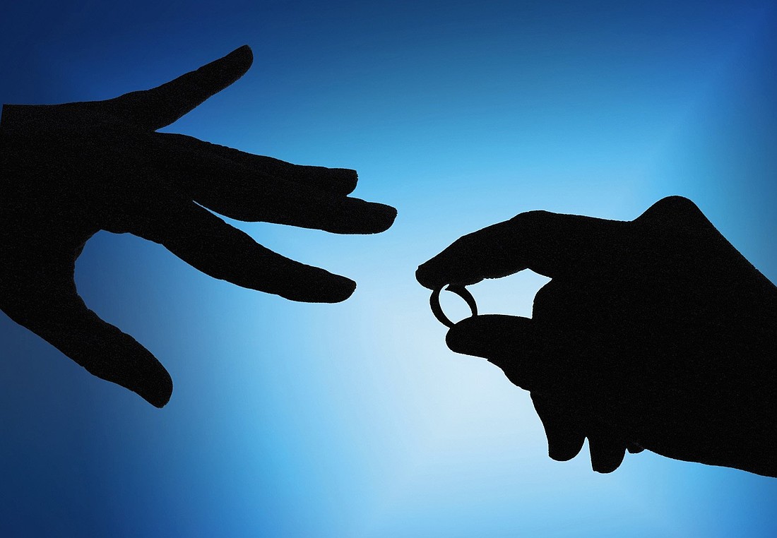 A hand holds a wedding ring in this undated illustration photo. (OSV News photo/Mike Crupi, CNS archive)