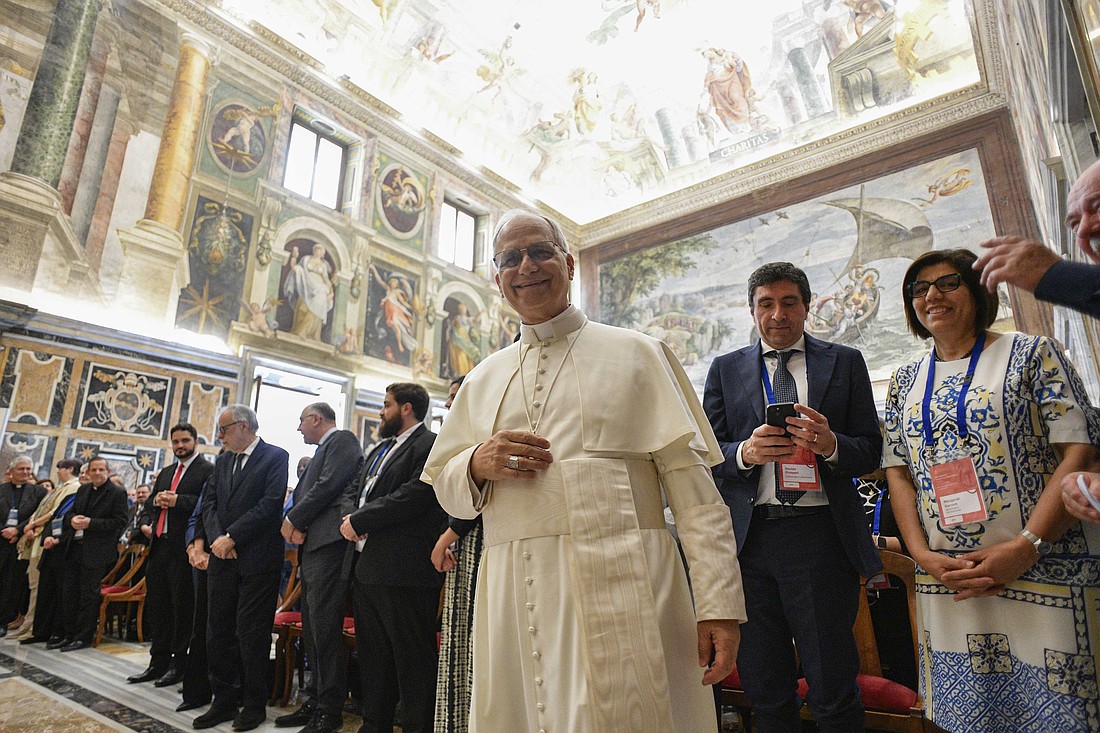 Pope Leo XIV smiles at the camera during meeting with leaders of 115 international Catholic associations, ecclesial movements and new communities in the Vatican's Clementine Hall June 6, 2025. At the right is Margaret Karram, president of the Focolare movement. (CNS photo/Vatican Media)