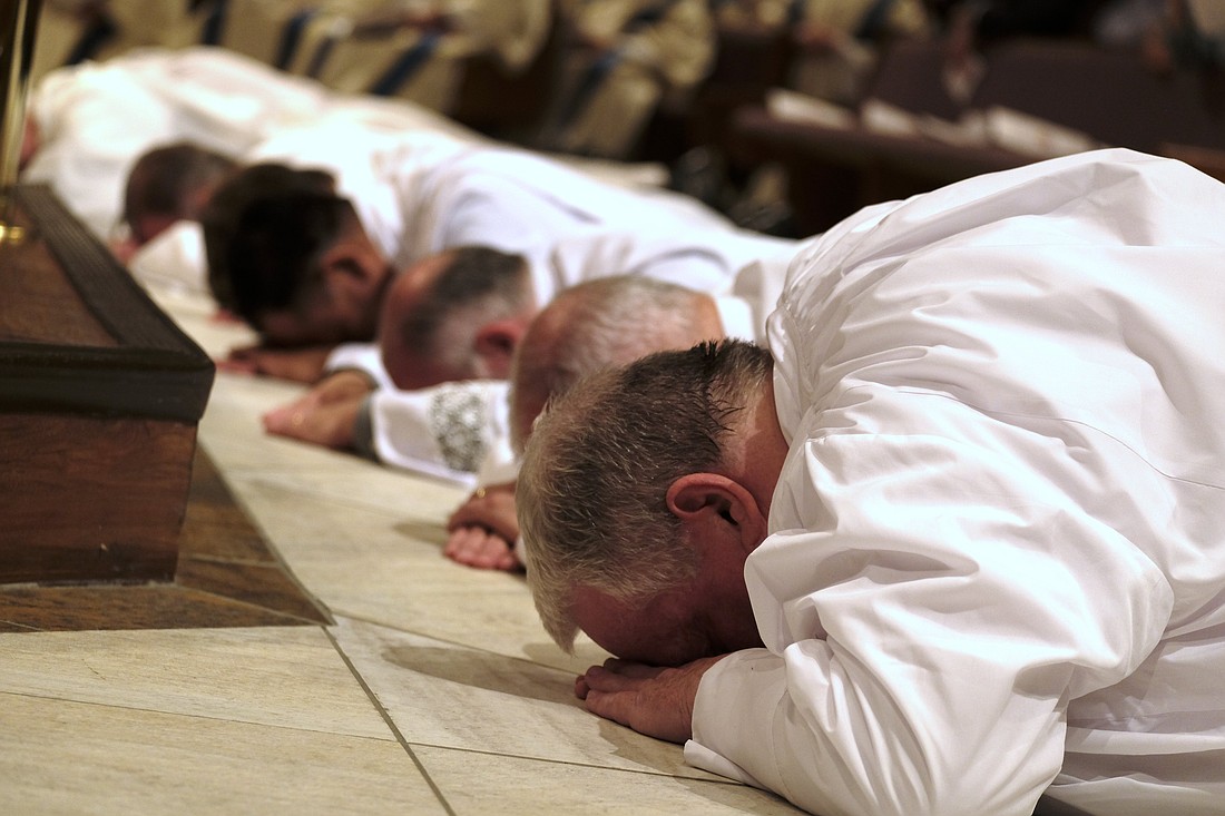 Men lie prostrate during their ordination to the diaconate at the Catholic Pastoral Center in Nashville, Tenn., April 1, 2023. (OSV News photo/Katie Peterson, Tennessee Register)