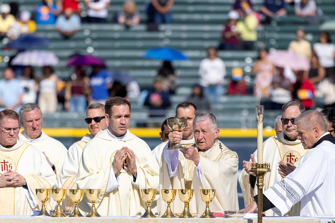 Chicago Cardinal Blase J. Cupich raises the Eucharist as he celebrates a June 14, 2025, Mass in honor of Pope Leo XIV at Rate Field in Chicago, home of the Chicago White Sox baseball team. The Chicago-born pontiff, elected May 8, is the first American pope in history. (OSV News photo/Carlos Osorio, Reuters)
