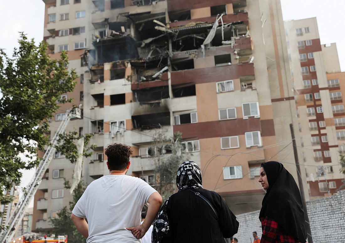People look at a damaged building in Tehran, Iran, June 13, 2025, in the aftermath of Israeli airstrikes. Israel attacked Iran early that morning in strikes that took out top military officers and hit nuclear and missile sites, raising the potential for an all-out war between the two bitter Middle East adversaries. It appeared to be the most significant attack Iran has faced since its 1980s war with Iraq. (OSV News photo/Majid Asgaripour, West Asia News Agency via Reuters)