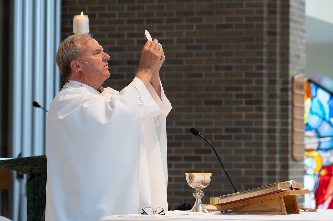 Father Scott Shaffer, pastor of St. Joseph Parish, Toms River, elevates the host during the recent Baccalaureate Mass he celebrated for the graduating seniors of Donovan Catholic High School. The Eucharist is the focal point of the Solemnity of of the Most Holy Body and Blood of Jesus which is commemorated the weekend of June 21-22. Matt Marzorati photo