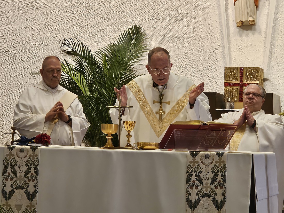 Bishop O'Connell celebrates Mass for the Solemnity of the Most Holy Body and Blood of Jesus June 21 in Corpus Christi Church, Willingboro. Father John Testa, pastor, right, concelebrated, and Deacon Gary Schmitt of Jesus the Good Shepherd Parish, Beverly, assisted.